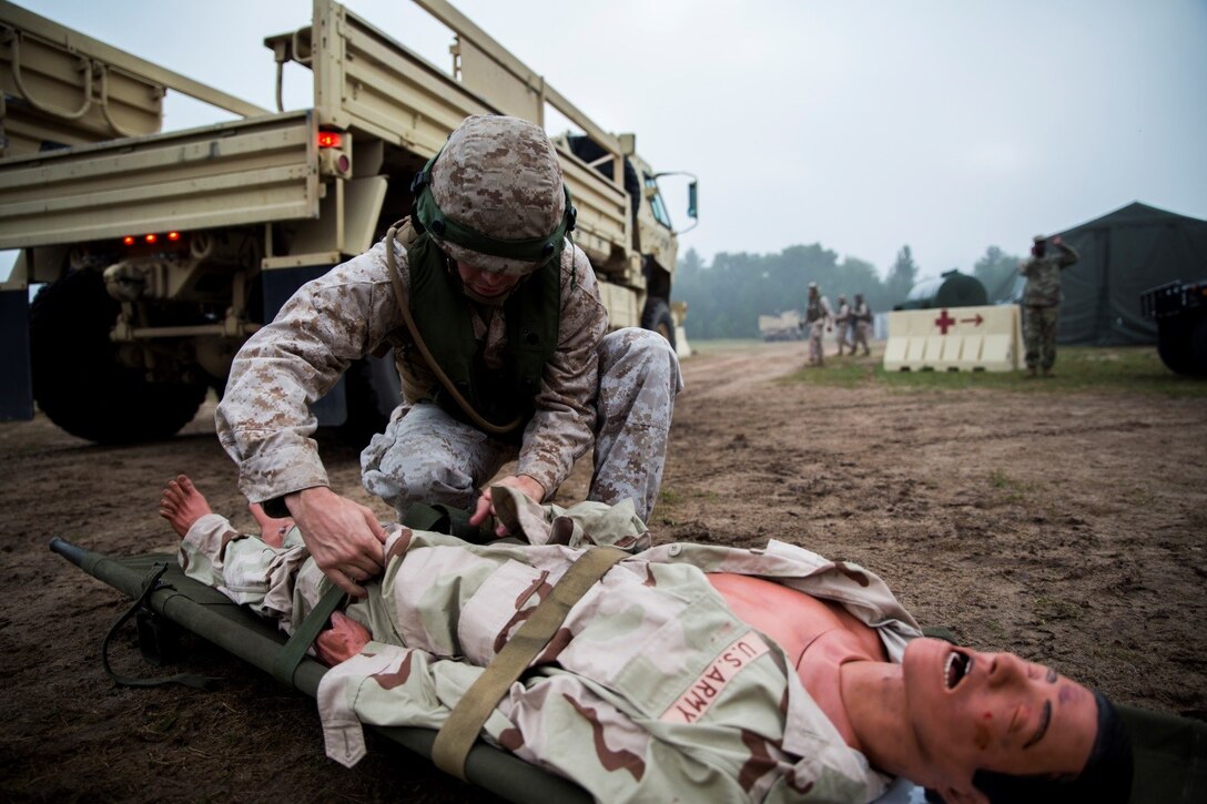 Sgt. Mathew W. Dearborn, data networking specialist with 4th Medical Battalion, 4th Marine Logistics Group, Marine Forces Reserve, searches a simulated casualty for weapons and contraband before he can be brought to the Shock Trauma Platoon for treatment during Exercise Global Medic at Fort McCoy, Wisconsin, Aug. 17, 2016. Marines provided security for the STP to ensure that victims were not hiding explosives or other harmful substances on their body and that unauthorized personnel were not entering the STP. (U.S. Marine Corps photo by Lance Cpl. Melissa Martens/Released)