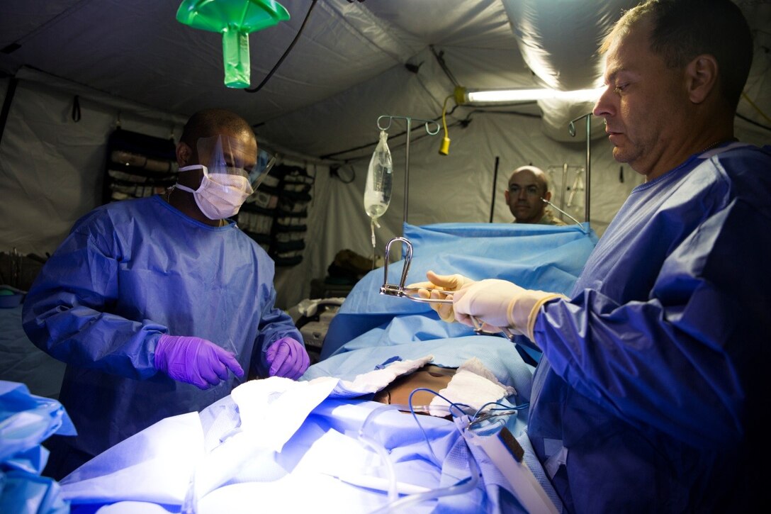 Petty Officer 3rd Class Pascal Augusma, hospital corpsman with 4th Medical Battalion, 4th Marine Logistics Group, Marine Forces Reserve, and Cmdr. Robert Jacoby, trauma surgeon with 4th Med. Bn., prepare a simulated casualty for surgery in the operating room during Exercise Global Medic at Fort McCoy, Wisconsin, Aug. 18, 2016. Throughout the course of the exercise, casualties would be brought to the operating room with various injuries and the medical staff would need to react quickly to stabilize the patient and provide the proper medical treatment. (U.S. Marine Corps photo by Lance Cpl. Melissa Martens/Released) 