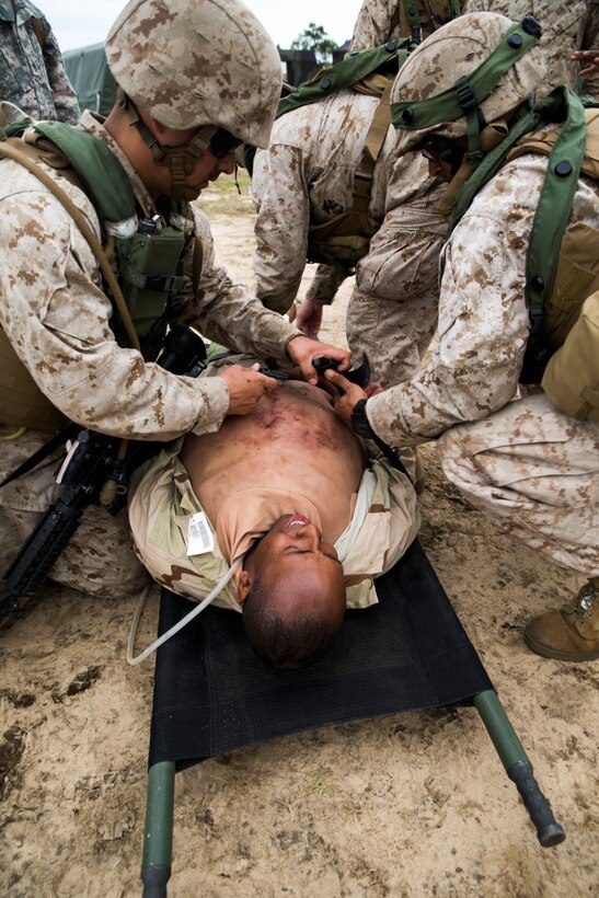 Marines and Hospital Corpsman prepare to bring a simulated casualty to the Shock Trauma Platoon for immediate medical care during Exercise Global Medic at Fort McCoy, Wisconsin, Aug. 18, 2016. The casualties were first searched for weapons and contraband before being taken in for medical care for assessment. Once the injuries were assessed, it was determined if the casualty needed to be taken in to the operating room, or if they were cleared to be sent to recovery. (U.S. Marine Corps photo by Lance Cpl. Melissa Martens/Released)) 