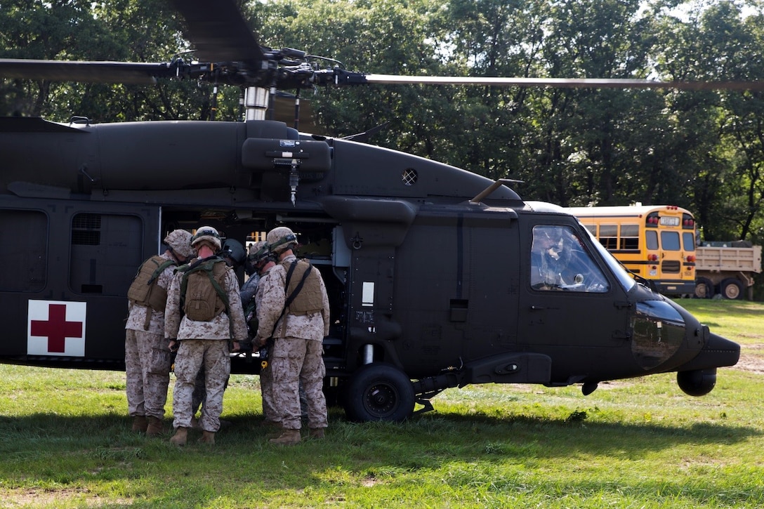 Marines and Navy personnel work together to quickly unload a simulated casualty who was brought in on a UH-60 Black Hawk helicopter during Exercise Global Medic at Fort McCoy, Wisconsin, Aug. 19, 2016. Once unloaded, the casualty was transported to the Shock Trauma Platoon where medical staff would provide the proper medical treatment for stabilization. (U.S. Marine Corps photo by Lance Cpl. Melissa Martens/Released)