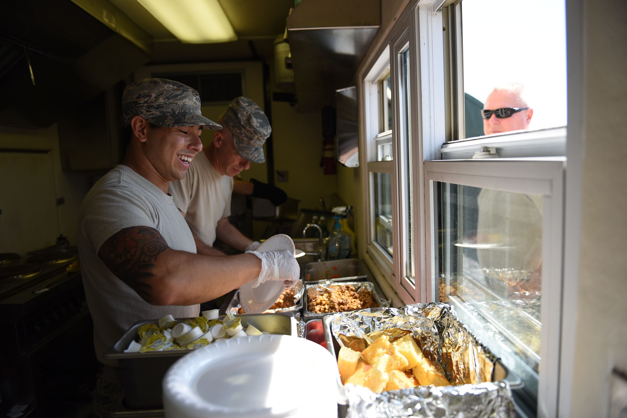 Staff Sgt. Fa Pham and Tech. Sgt. Randy Wright, members of the 911th Force Support Squadron, serve lunch to the 911th Civil Engineer Squadron during a training exercise at Fort Indiantown Gap, Pennsylvania, August 13, 2016. Services personnel accompanied the 911th CES on the two-day training exercise.(U.S. Air Force photo by Airman 1st Class Bethany Kobily)