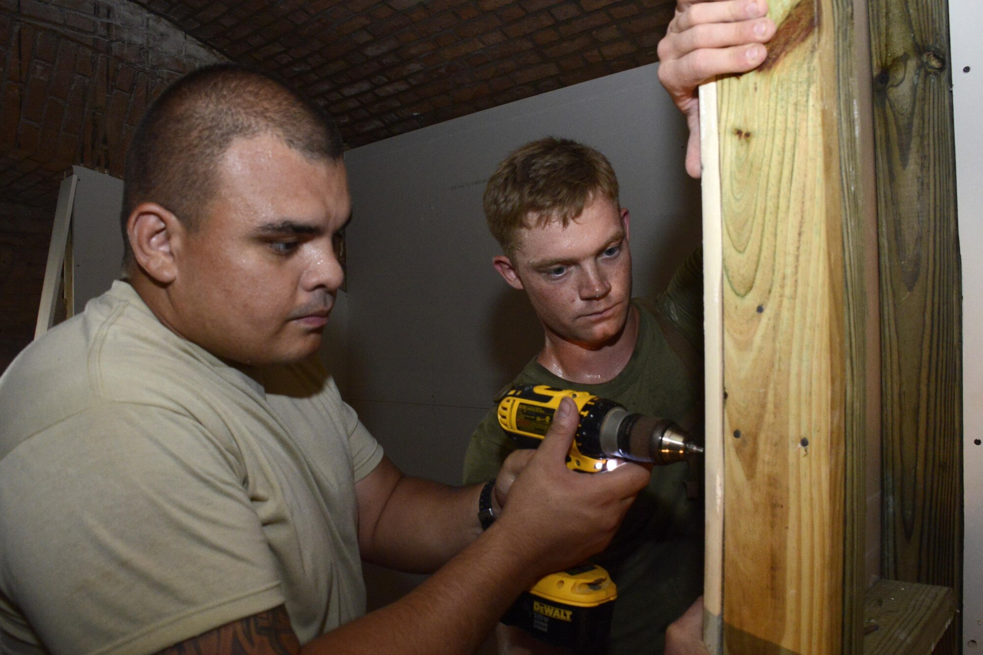 Marine Cpl. Thomas A. Trinosky, a 25th Combat Logistics Battalion combat engineer, and Senior Airman Michael Chinchilla, a 482nd Civil Engineering Squadron engineering assistant, secure a sheet of drywall during renovation efforts at Fort Jefferson, in the Dry Tortugas, Florida, Aug. 15. Airmen from the 482nd CES are renovating crew quarters for scientific research teams who visit the historical site studying wildlife in the area. The Innovative Readiness Training program allows Department of Defense and civilian entities partner together for projects like this. (U.S. Air Force photo by Senior Airman Frank Casciotta)