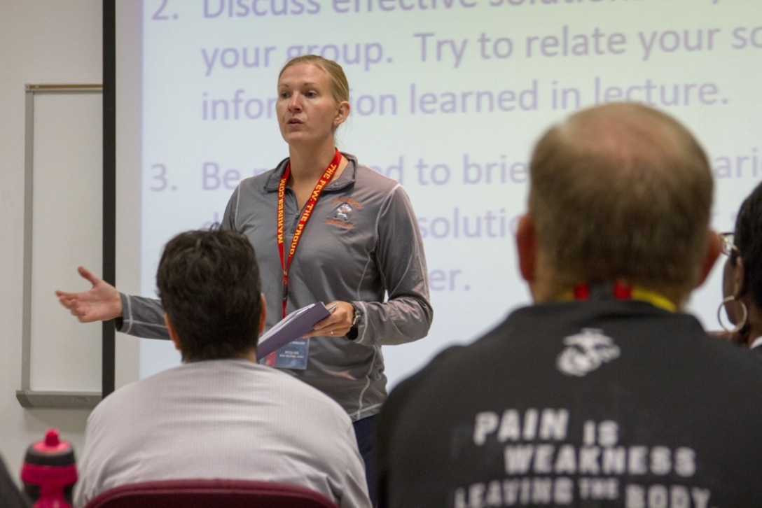 As part of a practical application, Becca Saal practices different briefing techniques with her fellow coaches during the 2016 Coaches Workshop at Marine Corps University aboard Marine Corps Base Quantico, Va., Aug. 4. The workshop creates a mutually beneficial relationship between coaches and the Marine Corps, where coaches can share knowledge about the Corps based on firsthand experience. Saal is the head volleyball coach for Carroll University in Waukesha, Wis.