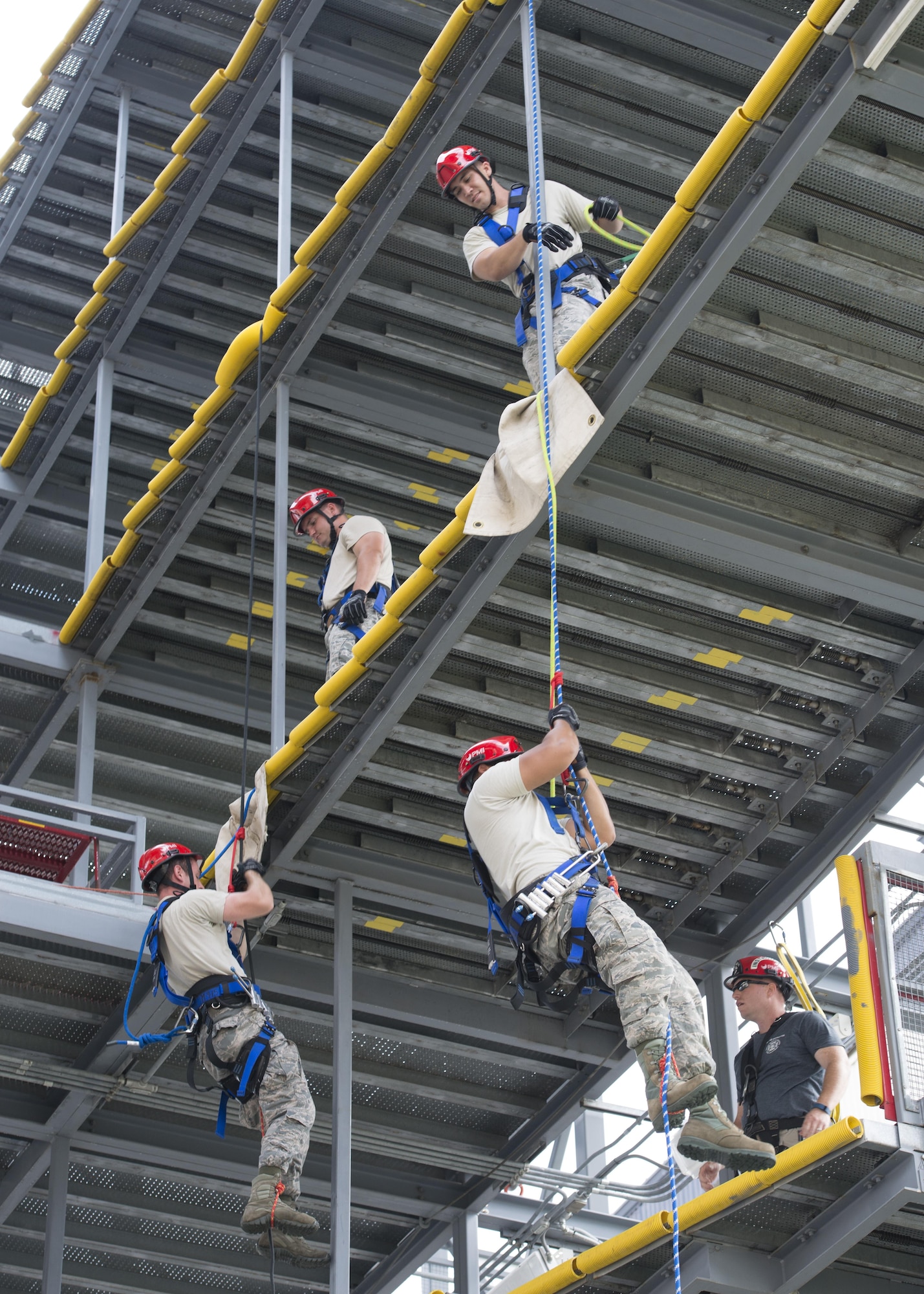 Four firefighters assigned to the 436th Civil Engineer Squadron Fire Department practice climbing and repelling during a Rescue Technician Course Aug. 18, 2016, from a mobile T-tail maintenance stand on Dover Air Force Base, Del. The T-tail stand allowed for a multitude of anchor points and levels to conduct training. (U.S. Air Force photo by Senior Airman Zachary Cacicia)