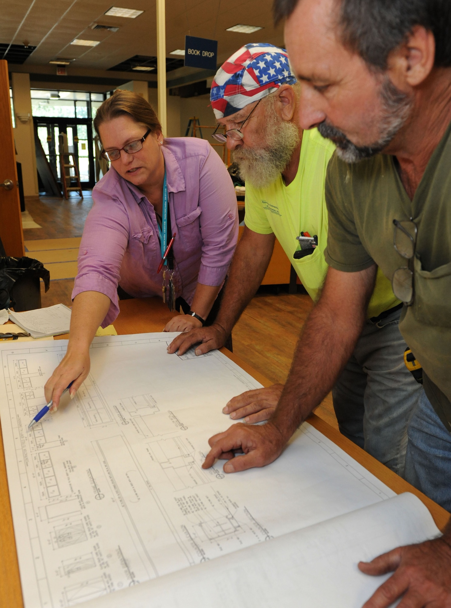 Michelle Bain, Base Operations facility space manager; Richard Taylor, Specialty Contractors and Associates, Inc. foreman; and Earl dean, DNP  , Inc. superintendent , review construction documents at the McBride Commons Aug. 22, 2016, on Keesler Air Force Base, Miss. The renovation will include a children’s library, computer stations, engraving, framing, marketing and print shops and a full kitchen. The nine-month-long project is expected to be completed by May 2017. (U.S. Air Force photo by Kemberly Groue/Released)
