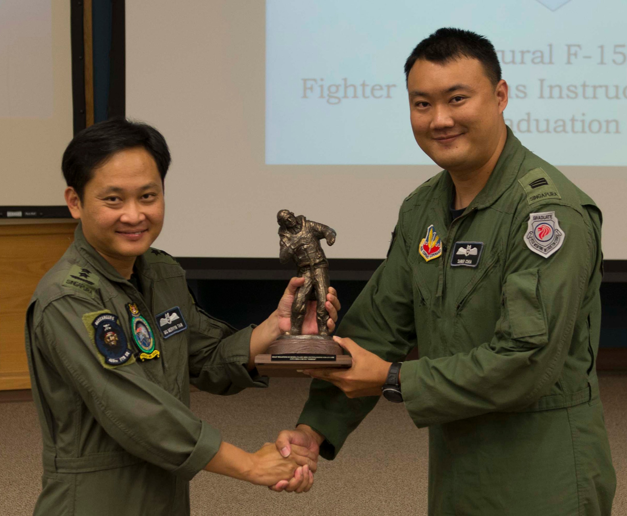 Republic of Singapore Air Force Maj. Gen. Mervyn Tan (left), Chief of RSAF, presents the top graduate award to Capt. Chia Chi Yu, 428th Fighter Squadron weapons systems officer, Aug. 19, 2016, at Mountain Home Air Force Base, Idaho. This was the first F-15SG Weapons Instructor course, designed to teach RSAF aircrew advanced combat maneuvers and tactics. (U.S. Air Force photo by Airman 1st Class Chester Mientkiewicz/Released)