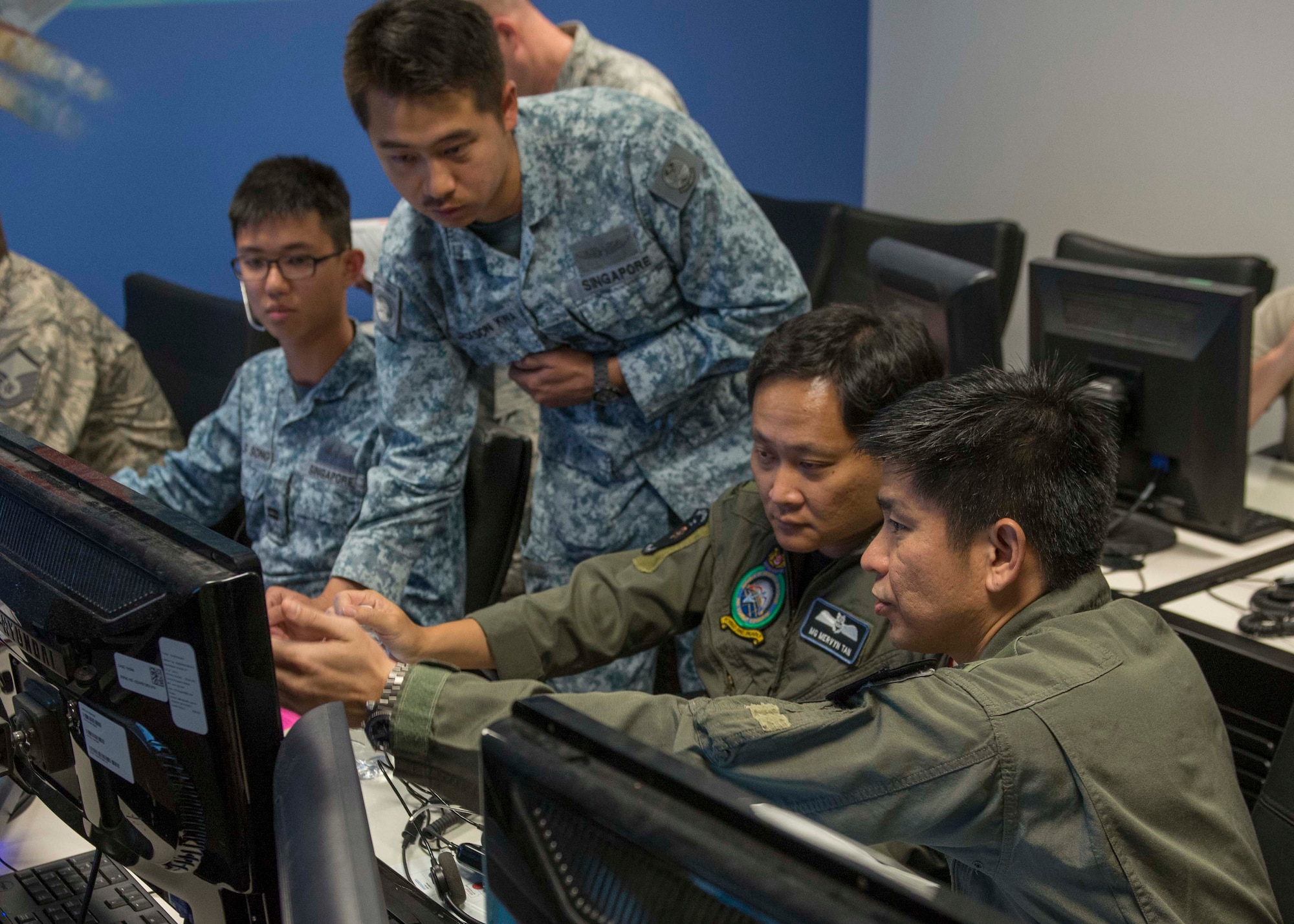 Republic of Singapore Capt. Jackson Kwa, 428th Fighter Squadron ground control intercept, shows an air-to-air dog fight to Major General Mervyn Tan, Chief of RSAF, and Brigadier General Tommy Tan Ah Han, RSAF Air Combat Command commander, Aug. 18, 2016, at Mountain Home Air Force Base, Idaho. The leaders visited different locations around base to experience the working relationship between the 428th FS and the rest of the Gunfighters. (U.S. Air Force photo by Airman 1st Class Chester Mientkiewicz/Released)