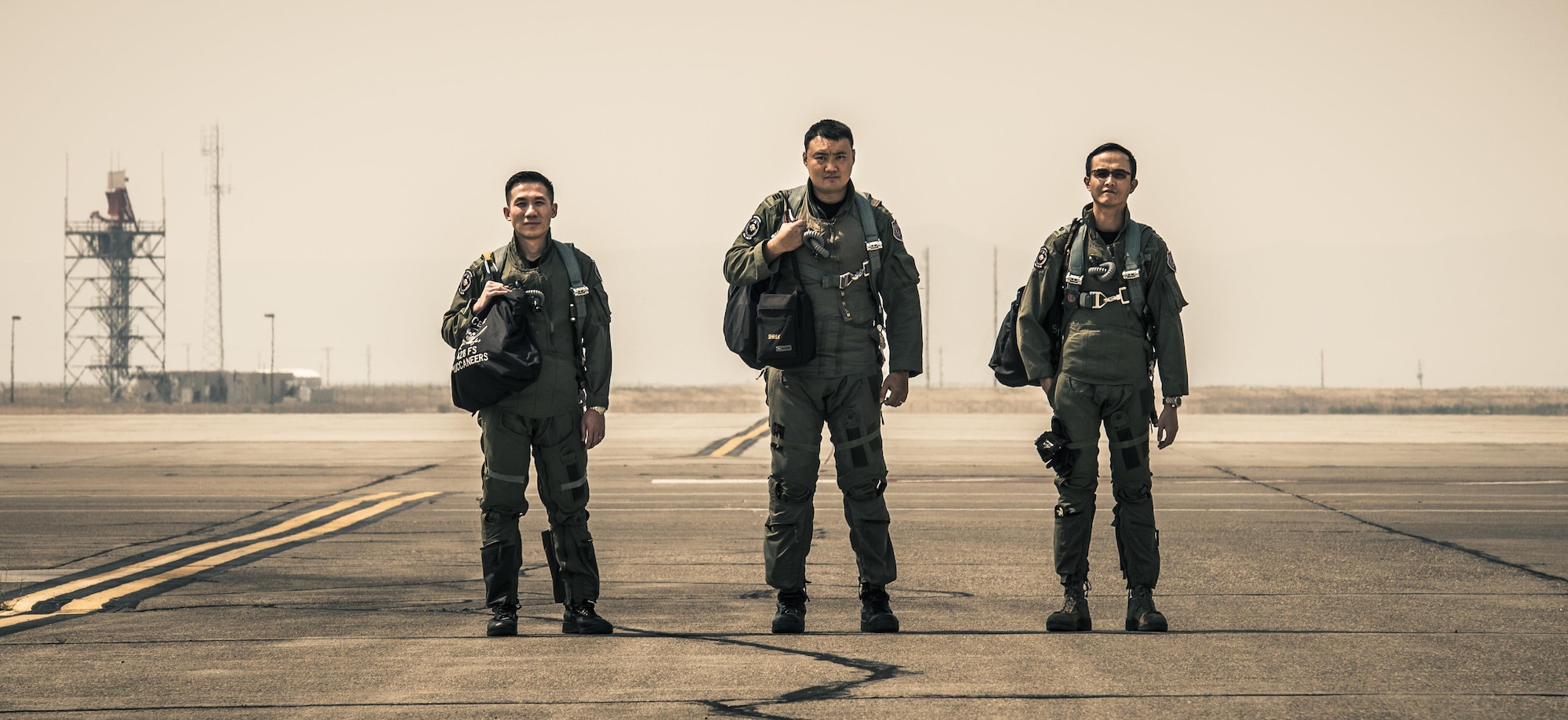 From the left, Republic of Singapore Air Force Weapons Systems Officers Capt. Alex Ong and Capt. Chia Chi Yu and F-15SG Pilot Maj. Wang Kee Yong stand on the flightline at Mountain Home Air Force Base, Idaho. The three are the first to graduate the RSAF Fighter Weapons Instructor Course, modeled after the U.S. Air Force Fighter Weapons School program. (U.S. Air Force photo by Senior Airman Lauren-Taylor Levin)