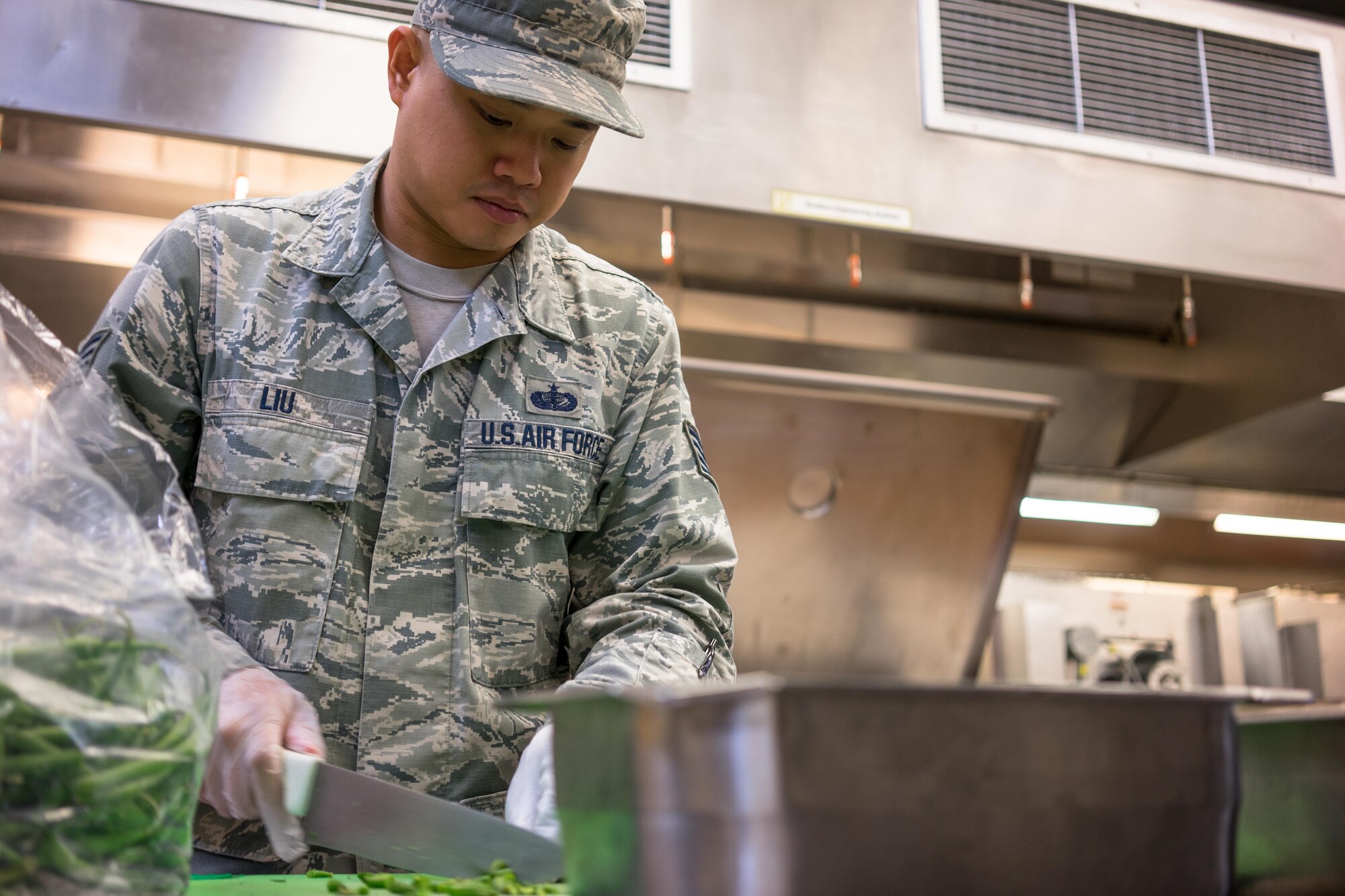 U.S. Air Force Staff Sgt. Jon Liu, 374th Force Support Squadron food services, prepares green beans for cooking at the Iditarod Dining Facility during Red Flag-Alaska at Joint Base Elmendorf-Richardson, Alaska, Aug. 20, 2016. Red Flag provides the opportunity for various units and career field to work together to in a simulated wartime environment. (U.S. Air Force photo by Staff Sgt. Michael Smith/Released)