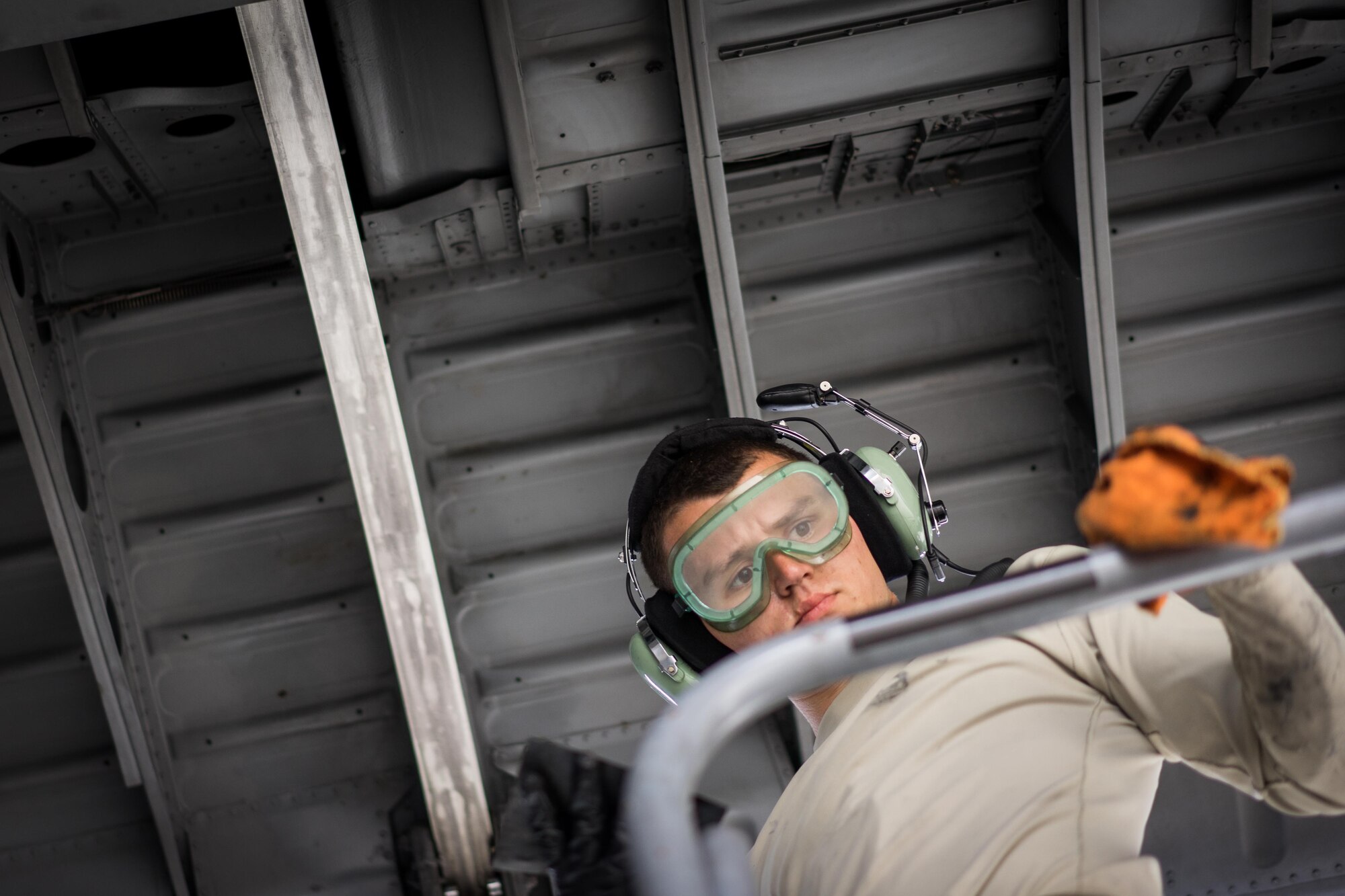 U.S. Air Force Airman 1st Class Joshua Yon, 374th Maintenance Squadron, reaches for a towel while cleaning underneath the wing of a C-130 Hercules during Red Flag-Alaska at Joint Base Elmendorf-Richardson, Alaska, Aug. 20, 2016. Red Flag provides joint offensive counter-air, interdiction, close air support, and large force employment training in a simulated combat environment. (U.S. Air Force photo by Staff Sgt. Michael Smith/Released)
