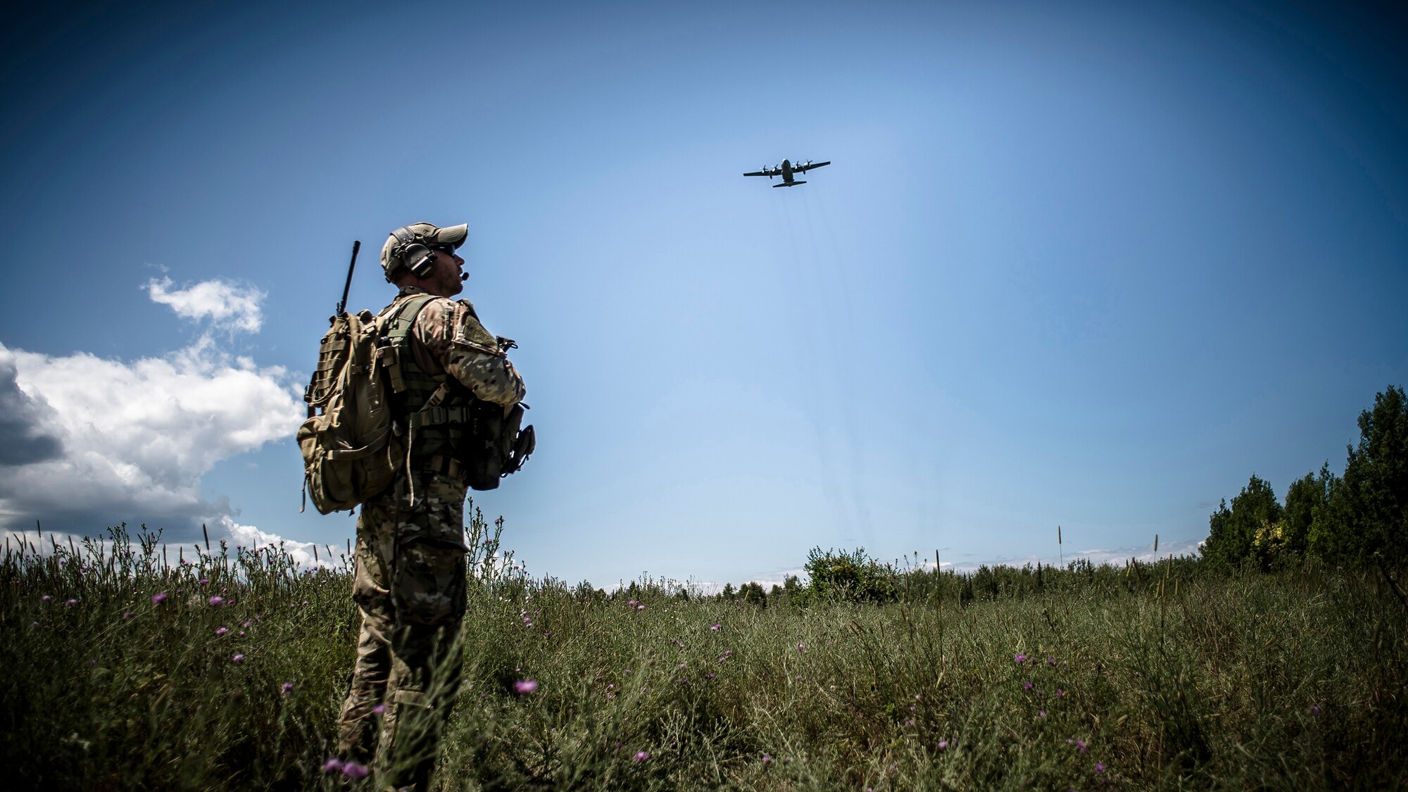 Polish armed forces joint terminal attack controller coordinate a resupply airdrop with a C-130 Hercules on an ambush training situation on July 21, 2015, with the 233rd Military Police Company, Springfield, Ill., provide security at Rogers City, Mich., during Exercise Northern Strike 2015. Exercise Northern Strike 2015 is a joint multi-national combined arms training exercise conducted in Michigan. (U.S. Air National Guard photo by Master Sgt. Scott Thompson/released)