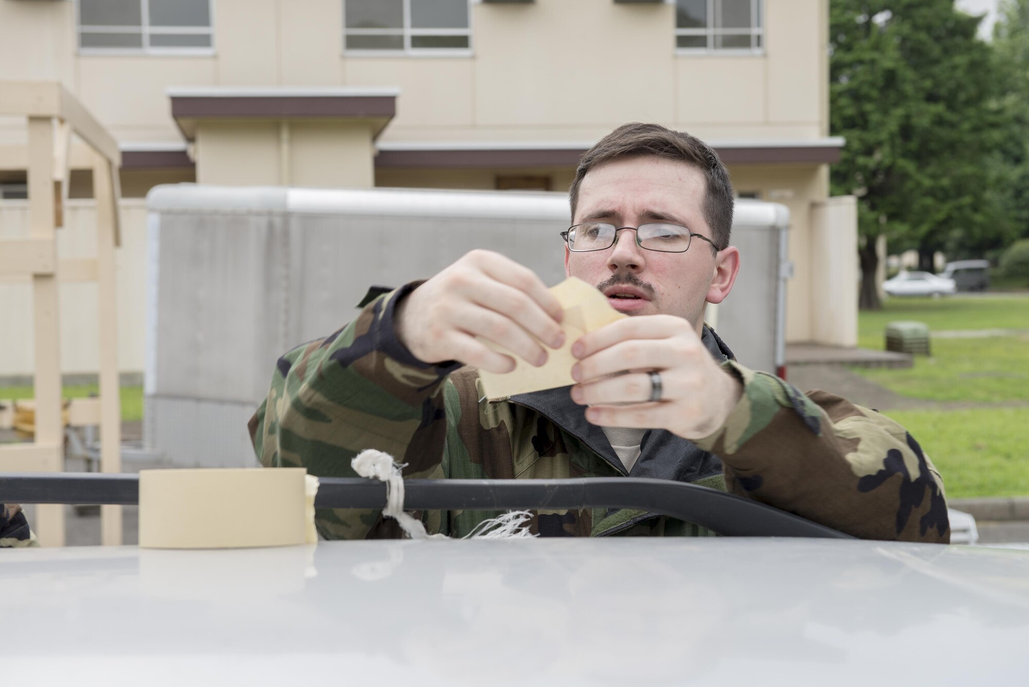 Senior Airman Adam Lieske, 374th Security Forces Squadron patrolman, places M8 chemical detection paper on a designated asset during a Chemical, Biological, Radiological, Nuclear and Explosives defense class at the Camp Warlord training ground at Yokota Air Base, Japan, Aug. 10, 2016. Camp Warlord provides Airmen the opportunity to practice asset protection and recovery in a hands-on environment. (U.S. Air Force photo by Senior Airman David C. Danford/Released)