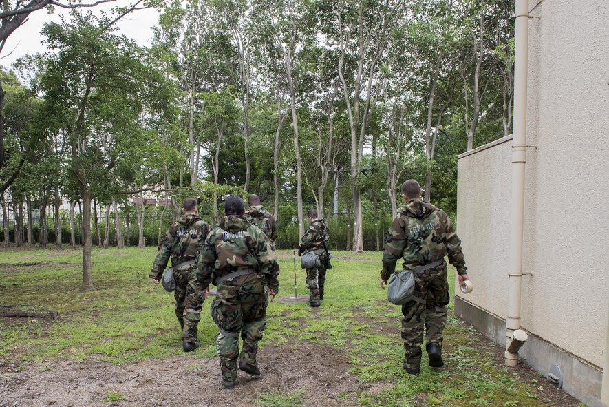Airmen place M8 chemical detection paper on stanchions during a Chemical, Biological, Radiological, Nuclear and Explosives defense class at the Camp Warlord training ground at Yokota Air Base, Japan, Aug. 10, 2016. The Airmen went through post attack reconnaissance procedures, along with performing chemical detection, asset protection and recovery. (U.S. Air Force photo by Senior Airman David C. Danford/Released)