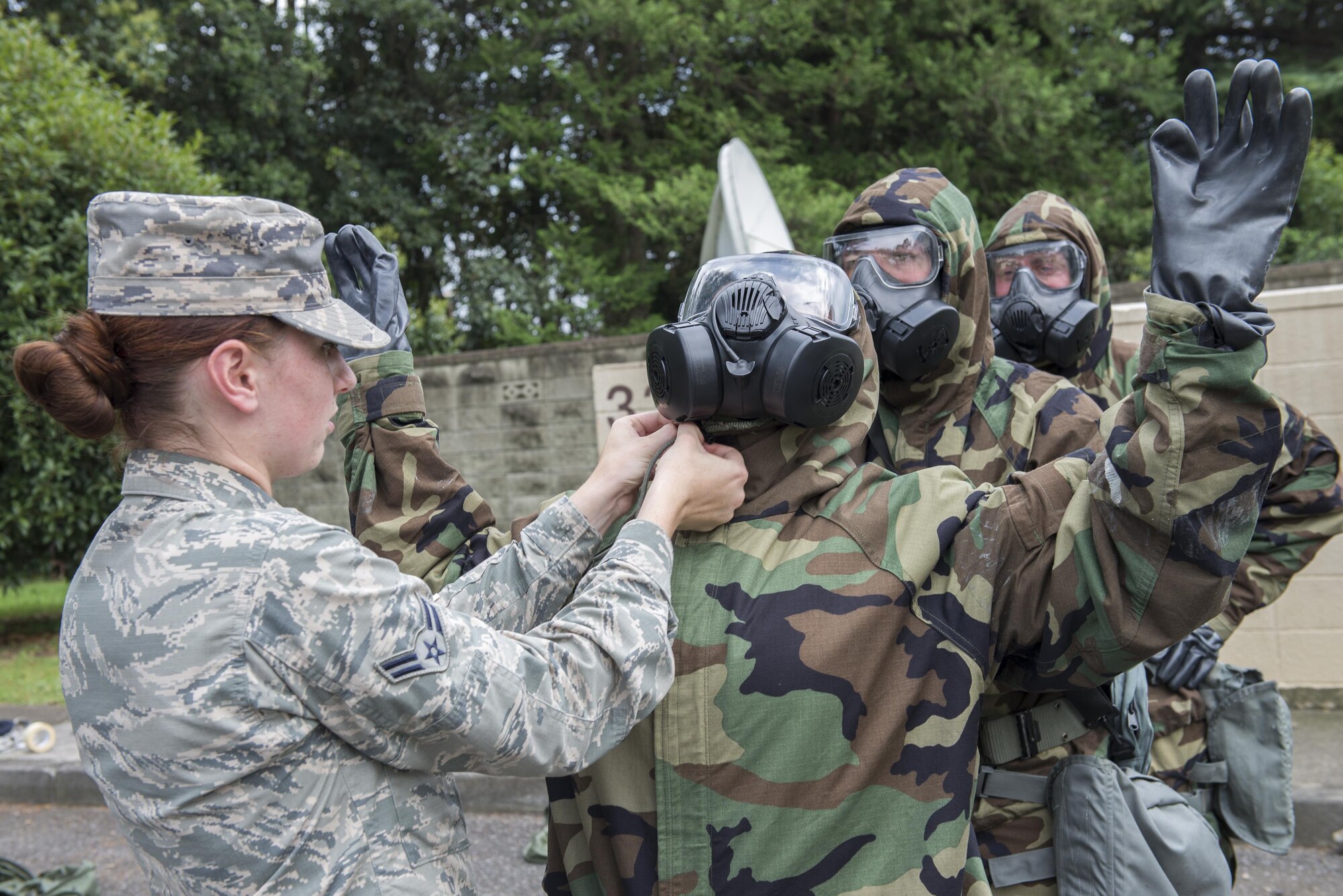 Airman 1st Class Elissa Humphrey, 374th Civil Engineer Squadron emergency management apprentice, inspects chemical protection gear during a Chemical, Biological, Radiological, Nuclear, Explosives defense class at the Camp Warlord training ground at Yokota Air Base, Japan, Aug. 10, 2016. These checks are important to ensure that airmen don the protective equipment correctly in preparation for real-world contingencies. (U.S. Air Force photo by Senior Airman David C. Danford/Released)