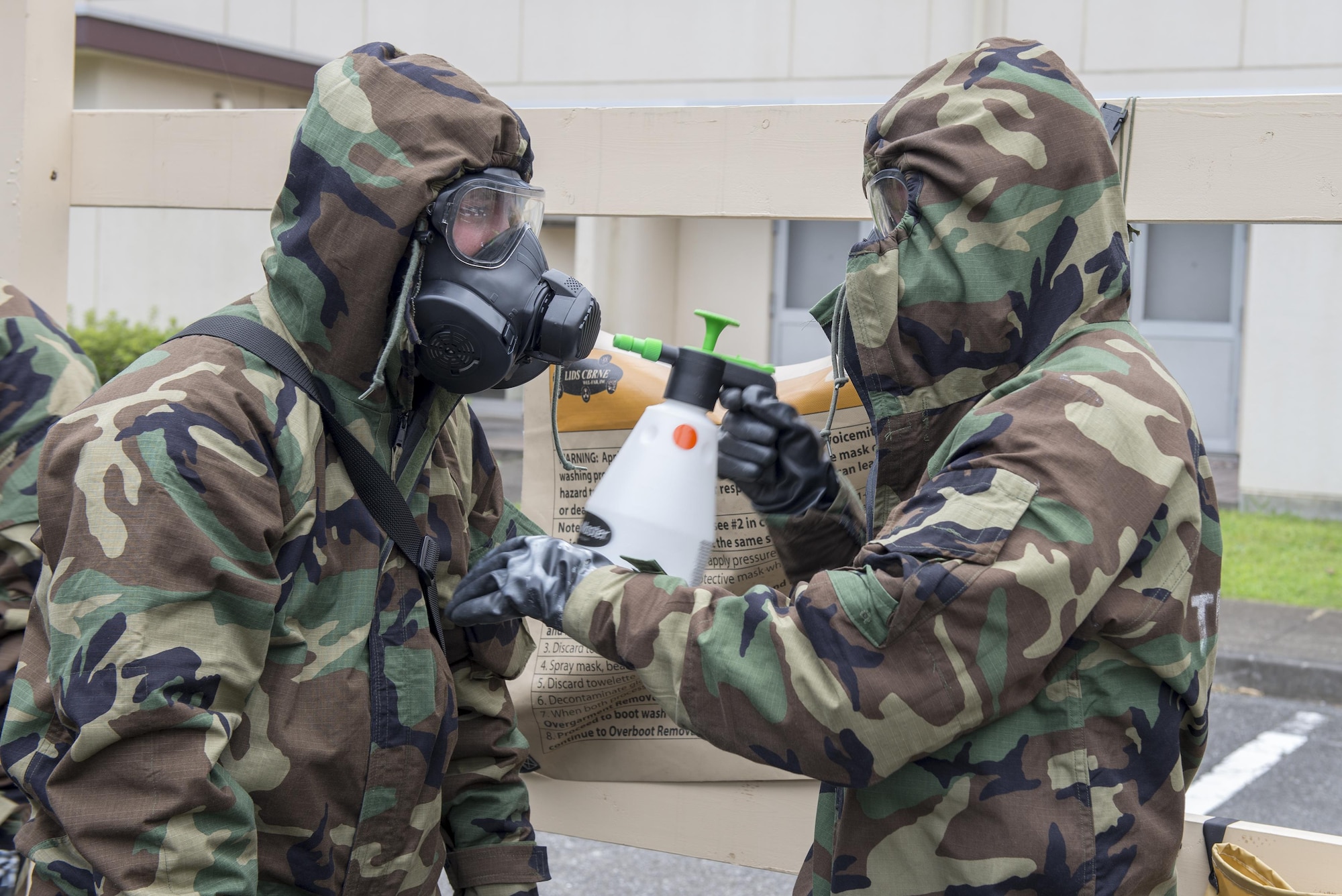 Airmen pass through a decontamination station during a Chemical, Biological, Radiological, Nuclear and Explosives defense class at the Camp Warlord training ground at Yokota Air Base, Japan, Aug. 10, 2016. The Airmen practiced CBRNE response, decontamination procedures and how to properly shelter-in-place. (U.S. Air Force photo by Senior Airman David C. Danford/Released)
