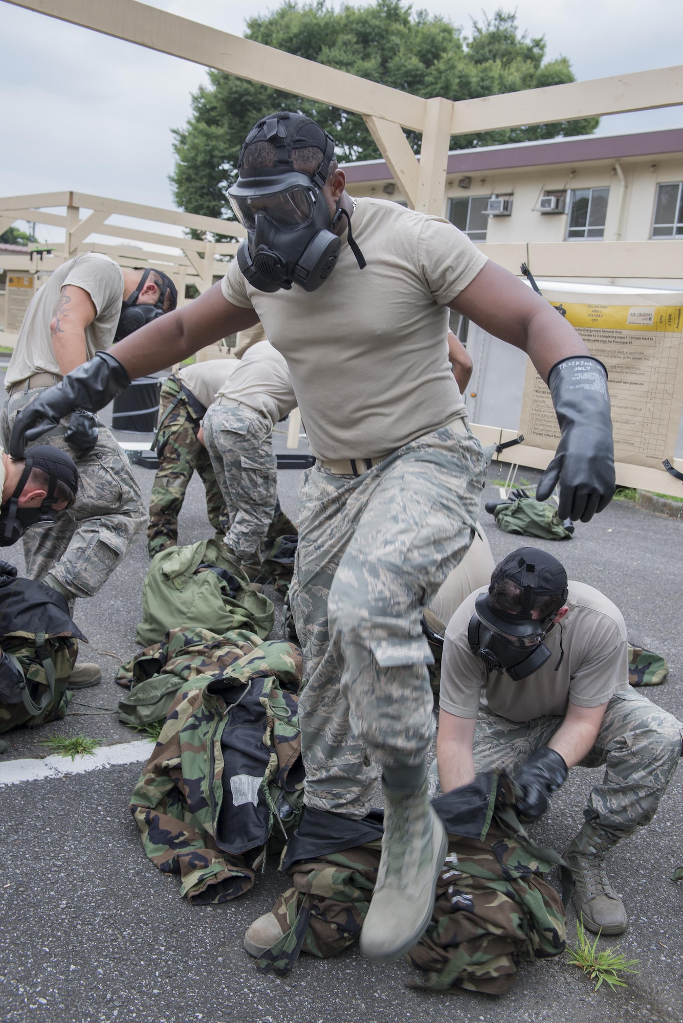 2nd Lt. Marvis Joseph, 374th Civil Engineer Squadron chief of asset optimization, steps out of his chemical protection gear during a Chemical, Biological, Radiological, Nuclear and Explosives defense class at the Camp Warlord training ground at Yokota Air Base, Japan, Aug. 10, 2016. The Airmen practiced CBRNE response, decontamination procedures and how to properly shelter-in-place. (U.S. Air Force photo by Senior Airman David C. Danford/Released)