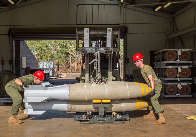Sgt. Joel Farmer, left, aviation ordnance technician and quality assurance officer, and Cpl. Michael Konicki, right, aviation ordnance technician team member, assigned to Marine Aviation Logistics Squadron (MALS) 12, load bombs onto a bomb skid during Southern Frontier at Royal Australian Air Force Base Tindal, Australia, Aug. 22, 2016. The bomb skid will then be transported to the line, where the munitions are loaded on to aircraft. Southern Frontier afforded Iwakuni Marines the opportunity to train with high explosive weapon body groups typically not used in Japan, while expanding technical and tactical proficiency in their craft. Munitions built during this training are in support of Marine Fighter Attack Squadron (VMFA) 122, who also gain experience and qualifications in low altitude, air-ground, high explosive ordnance delivery at the unit level. (U.S. Marine Corps photo by Cpl. Nicole Zurbrugg)
