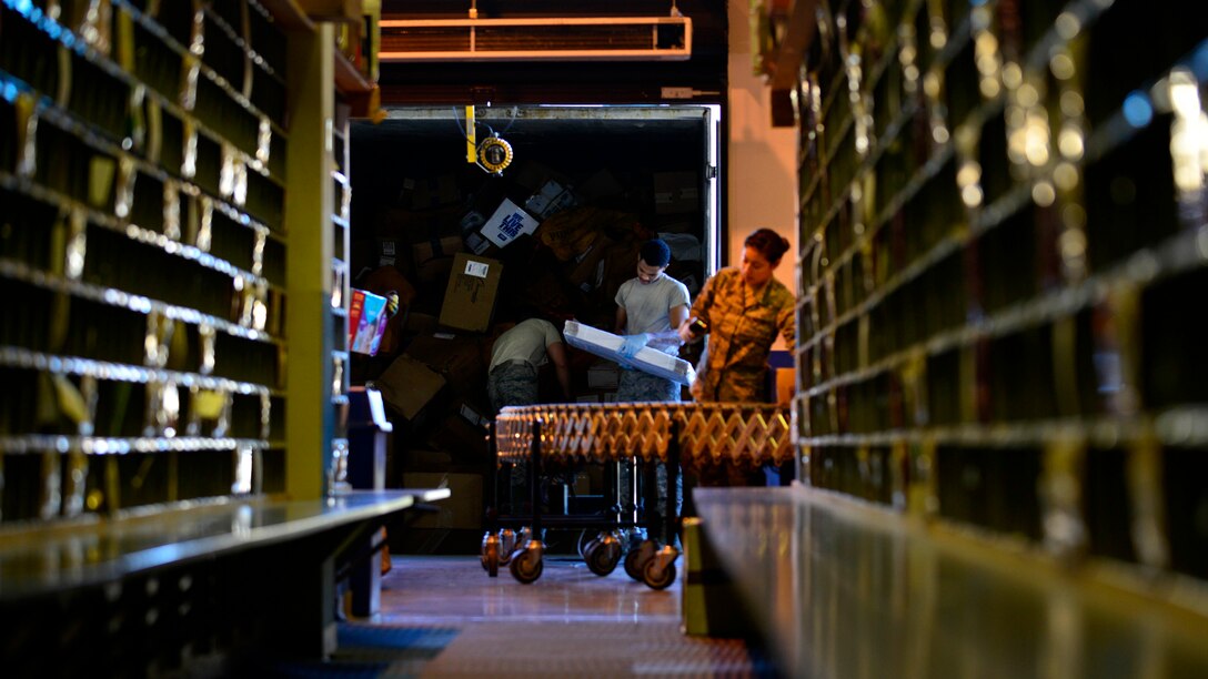 Airmen from the 31st Communication Squadron postal office unload and process packages, Aug. 22, 2016, at Aviano Air Base, Italy. The package truck delivery dates recently changed due to transportation delays in Milan, Italy, requiring postal service Airmen to handle deliveries in half the time.  (U.S. Air Force photo by Airman 1st Class Cary Smith/Released)