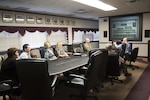 Army Col. William Krahling, director of United States European Command and United States African Command Regional Operations, and his staff receive a command brief, given by Jim McCormack, deputy director of DLA Distribution business development.