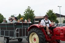 Norbert Assmann, a vehicle dispatcher with the 52nd Logistic Readiness Squadron vehicle operations section, Spangdahlem Air Base, Germany, gives a group of people a tractor ride around Club Eifel at Spangdahlem Aug. 18, 2016 as part of Multicultural Awareness Day. Assmann and 250 other Sabers and people from the local community volunteered to work at the annual event at Spangdahlem designed to showcase diverse cultures through displays, performances, food and fashion. (U.S. Air Force photo by Tech. Sgt. Amanda Currier)  