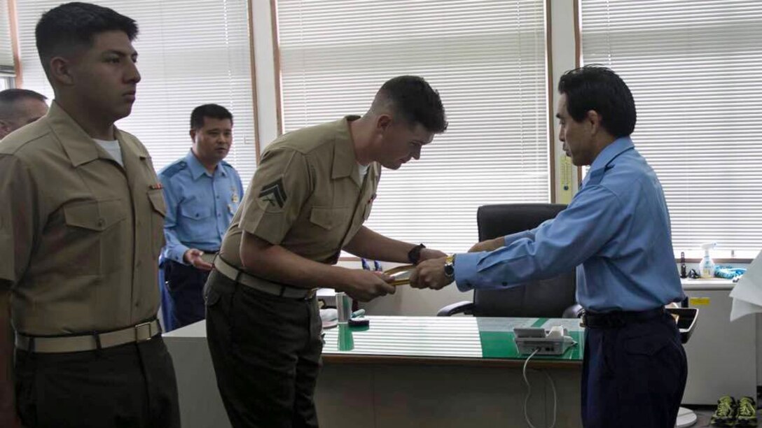 Lance Cpl. Luis Rosas, left, and Cpl. Ian Burnham, right, are presented a letter of appreciation by Eikatsu Sakihara, the Chief of the Urasoe City Police Department at the Urasoe City Police Department, Okinawa, Japan, Aug. 23, 2016. Rosas and Burnham were awarded for their efforts in assisting an Okinawa resident from a burning vehicle, and eliminating hazards at the scene of a car crash on April 16. Rosas is a Wilmington, Calif. native, and an engineer equipment mechanic with Combat Logistics Regiment-35, 3rd Maintenance Bn., 3rd Marine Logistics Group, III Marine Expeditionary Force. Burnham is a Spokane, Washington native, and electrical engineer equipment systems technician with CLR-35, 3rd Maintenance Bn., 3rd MLG, III MEF.