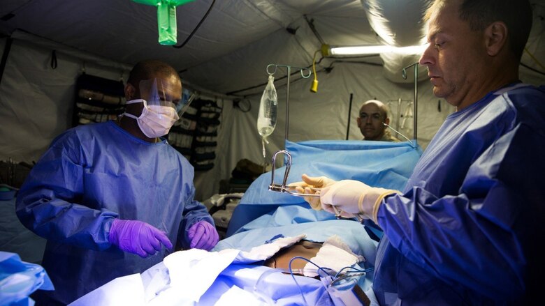 Cmdr. Robert Jacoby, trauma surgeon with 4th Medical Battalion, right, 4th Marine Logistics Group, Marine Forces Reserve, and Petty Officer 3rd Class Pascal Augusma, left, hospital corpsman with 4th Medical Battalion, prepare a simulated casualty for surgery in the operating room during Exercise Global Medic at Fort McCoy, Wisconsin, August 18, 2016. Throughout the course of the exercise, casualties would be brought to the operating room with various injuries and the medical staff would need to react quickly to stabilize the patient and provide the proper medical treatment. 