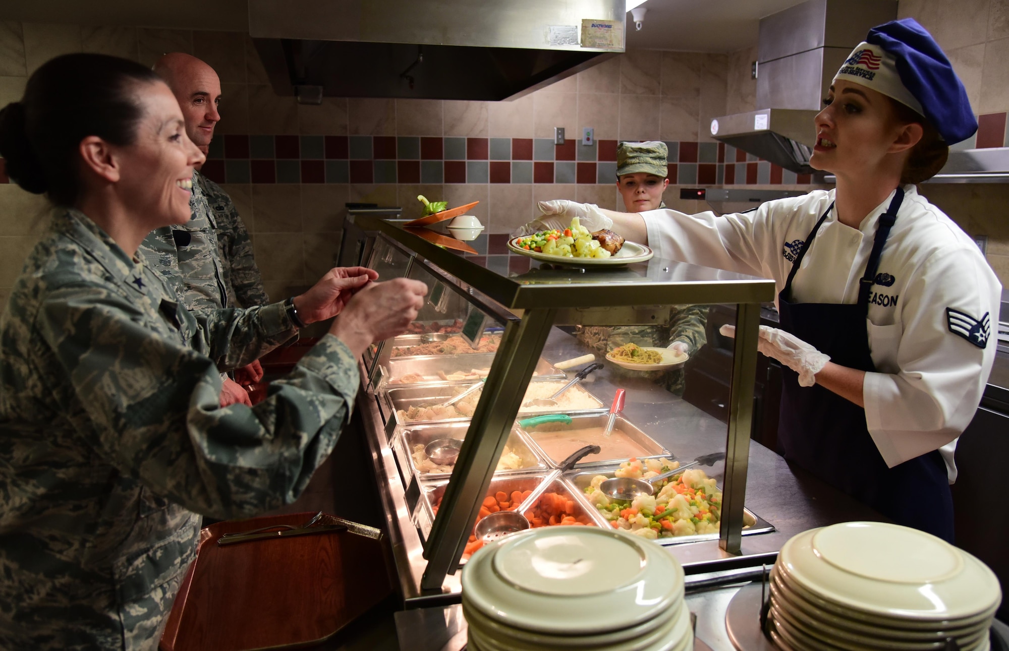PETERSON AIR FORCE BASE, Colo. - Brig. Gen. Pamela Lincoln, 14th Air Force mobilization assistant to the commander, is served lunch by Senior Airman Taylor Deason, 21st Force Support Squadron food services specialist, at the Aragon Dining Facility on Peterson Air Force Base, Colo., Aug. 16, 2016. Lincoln dined and met with Airman from across the base. (U.S. Air Force photo by Staff Sgt. Amber Grimm) 