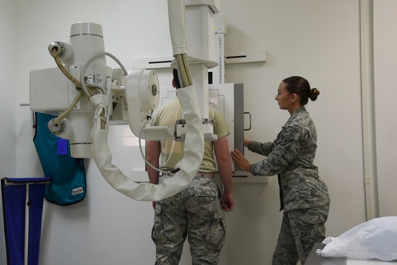 Airman 1st Class Rachael O’Keefe, 21st Medical Support Squadron radiology technologist, places a cassette in the machine to take a spinal X-ray at Peterson Air Force Base, Colo., Aug. 22, 2016. O’Keefe finds her interactions with her patients to be what eases her stress after a long day. (U.S. Air Force photo by Dave Meade)