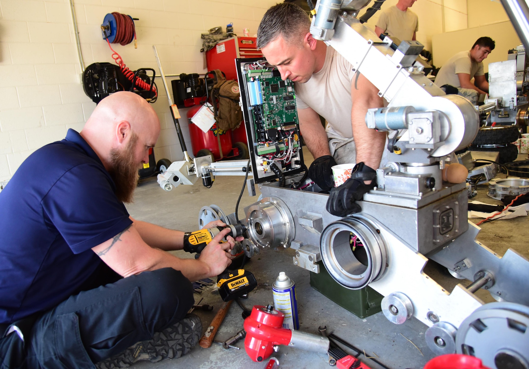 Technical Sgt. Dustin Frey, 140th Wing Civil Engineer Squadron explosive ordnance disposal technician, assists Jack Caylor, Northrop Grumman Remotec robotic instructor, remove a difficult component during a maintenance class at Peterson Air Force Base, Colo., Aug. 17, 2016. The 21st Civil Engineer Squadron EOD shop hosted the 140th Wing CES EOD out of Buckley Air Force Base, Colo., the 302nd Airlift Wing CES EOD at Peterson AFB, Colo., and the El Paso County bomb squad for an advanced maintenance course held here August 15-19. (U.S. Air Force photo by Staff Sgt. Amber Grimm) 