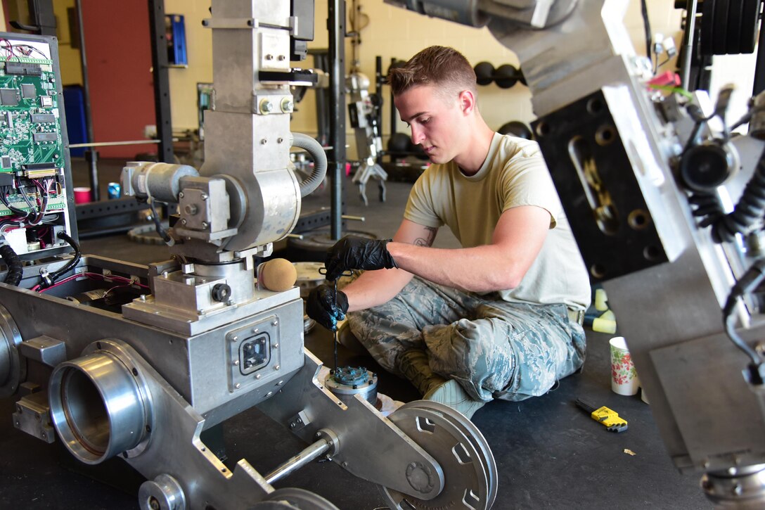 Senior Airman Nicholas Stewart, 21st Civil Engineer Squadron explosive ordnance disposal technician, applies lubricant to an actuator part of an Northrop Grumman Remotec’s ANDROS F6A EOD robot during a maintenance class at Peterson Air Force Base, Colo., Aug. 17, 2016. The 21st EOD leadership tries to arrange this training for their Airman every two to three years to make sure they are fully capable of performing any trouble shooting that might be necessary. (U.S. Air Force photo by Staff Sgt. Amber Grimm)