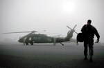 An instructor pilot walks onto the flightline while maintenance crews inspect at UH-60M Black Hawk helicopter at Lowe Army Heliport, Fort Rucker, Ala. in a dense fog that blanketed lower part of the state for several hours on the morning of May 9, 2013. Maintenance of existing equipment is crucial to keeping operating costs low for the multi-functional aircraft that has been used around the world for the past three decades. (U.S. Army photo by Sgt. 1st Class Andrew Kosterman/Fort Rucker public affairs).