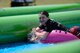 Kelly Caggiano tubes down a giant slip-and-slide during Slide the City at Schriever Air Force Base, Colorado, Friday, Aug. 19, 2016. The 50th Force Support Squadron brought the popular event back to the base for a second straight year as part of the squadron’s continued efforts to improve the quality of life for Team Schriever and their families. (U.S. Air Force photo/Christopher DeWitt)