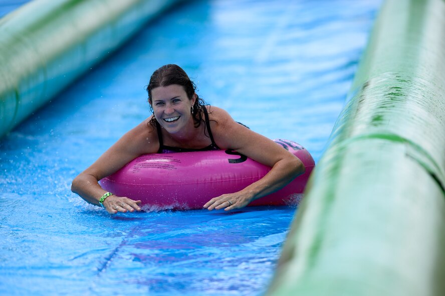 Janell Canaan smiles while tubing down a giant slip-and-slide during Slide the City at Schriever Air Force Base, Colorado, Friday, Aug. 19, 2016. The 50th Force Support Squadron brought the popular event back to the base for a second year as part of the squadron’s continued efforts to improve the quality of life for Team Schriever and their families.(U.S. Air Force photo/Christopher DeWitt)