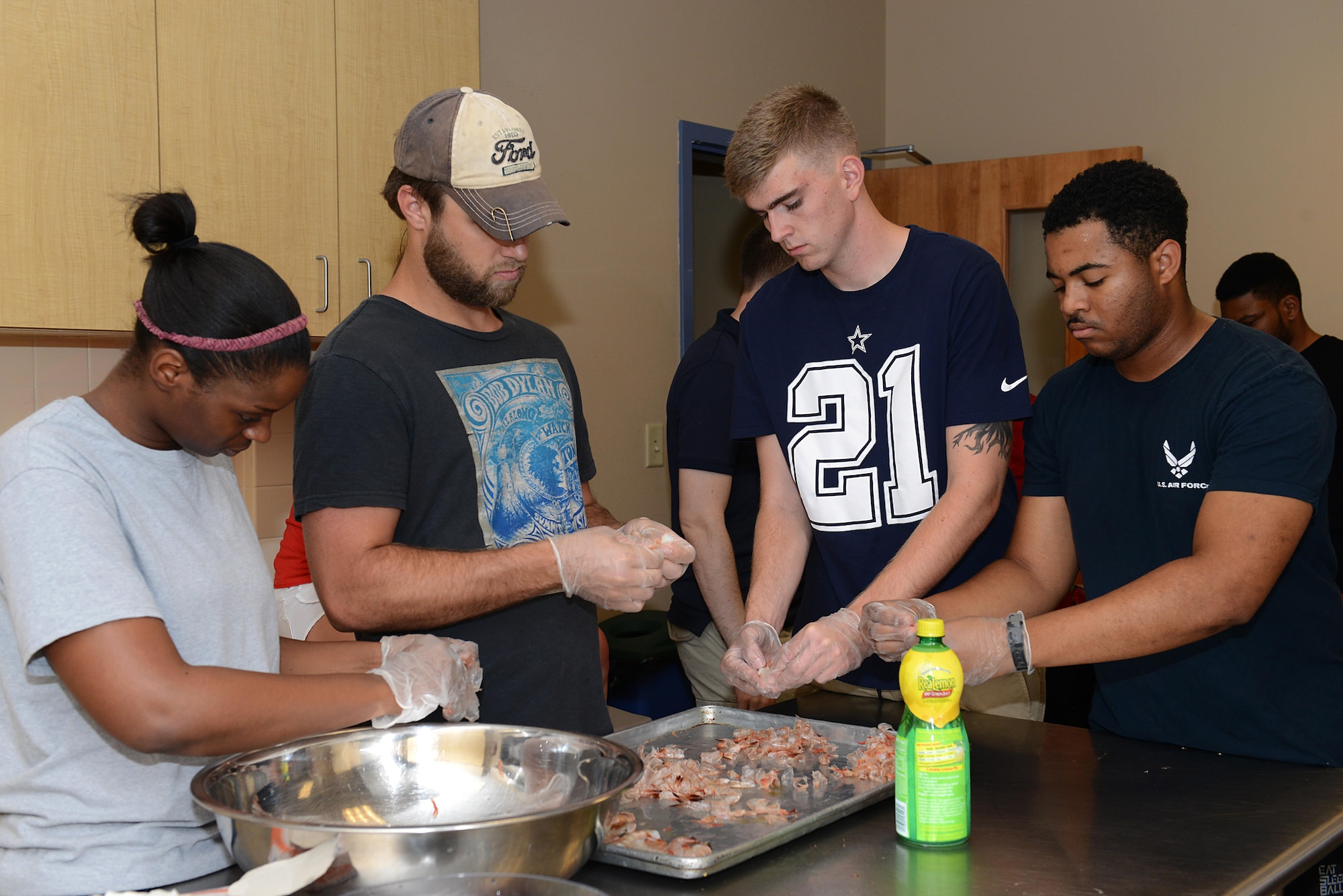 Students peel shrimp during a cooking class at the Community Commons at Langley Air Force Base, Va., Aug. 16, 2016. During the three-day cooking class, students learned to make a variety of simple recipes including crab cakes, salmon, jasmine rice and potatoes. (U.S. Air Force photo by Staff Sgt. Teresa J. Cleveland)