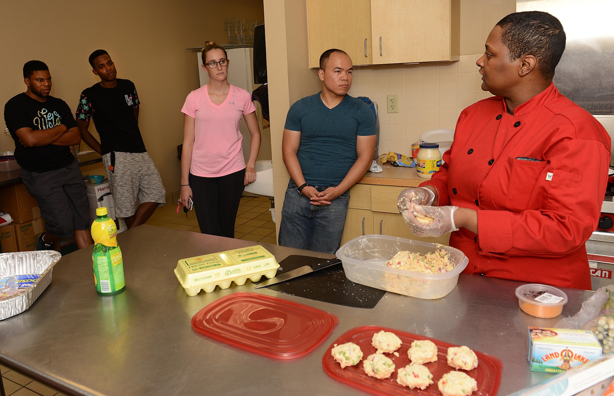 Sonnica Jones answers questions from students during a cooking class at the Community Commons at Langley Air Force Base, Va., Aug. 16, 2016. During the class, Jones provided information regarding recipes and cooking techniques to Airmen who live in the dorms as well as those who live in the local community. (U.S. Air Force photo by Staff Sgt. Teresa J. Cleveland)