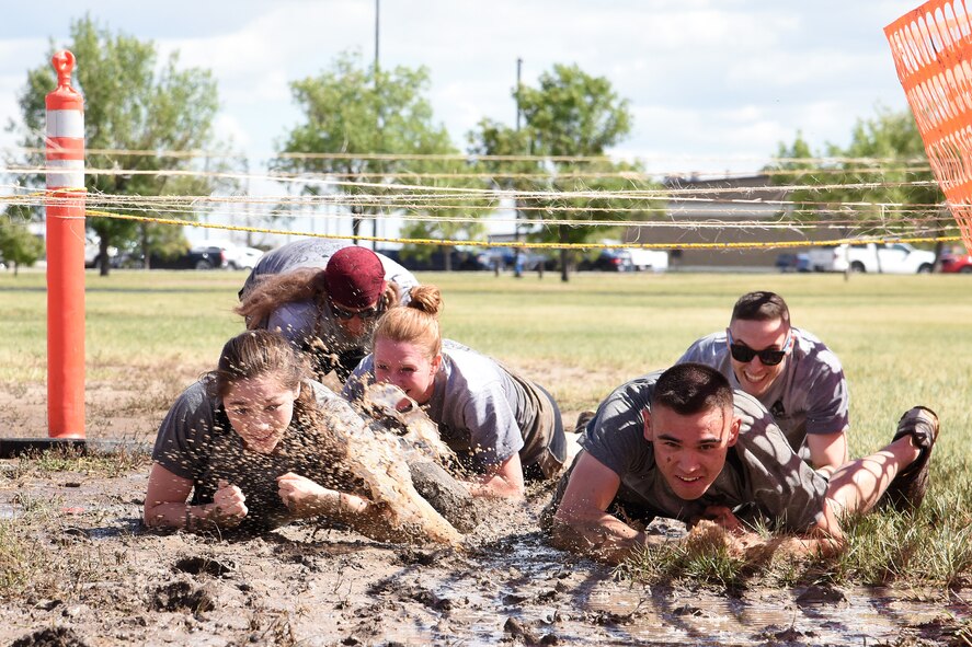 Airmen assigned to the 341st Missile Wing low crawl through mud in the base’s first mud run hosted by the 341st Maintenance Group Aug. 19, 2016, at Malmstrom Air Force Base, Mont. The competitors had to complete obstacles designed to build teamwork and be fun. (U.S. Air Force Base photo/Senior Airman Jaeda Tookes)