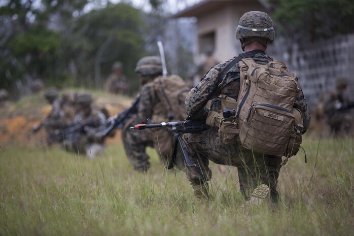 U.S. Marine Corps Lance Cpl. Taylor Abbot (right), rifleman, Company E, Battalion Landing Team 2nd Battalion, 4th Marines, (BLT) 31st Marine Expeditionary Unit provides security while conducting a Helo Raid at Combat Town, Okinawa, Japan, Dec. 8, 2014. Company E is conducting training as part of the MEU Exercise and pre-deployment training. (U.S. Marine Corps Photo by Lance Cpl. Richard Currier/ Released)