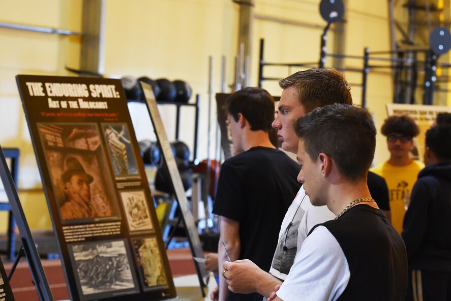 Ellicott High school students read informational poster boards in the “Holocaust museum” exhibit during Holocaust Remembrance Day at Schriever Air Force Base, Colorado, Tuesday, Aug. 23, 2016. The boards detailed important events during the Holocaust. See other photo for additional information. (U.S. Air Force photo/Airman William Tracy)