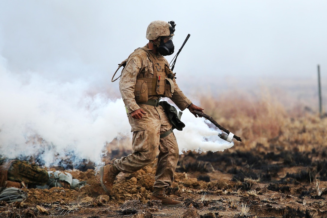 A Marine Corps range safety officer spreads tear gas during live-fire training as part of Exercise Koolendong 16 at Bradshaw Field Training Area, Northern Territory, Australia, Aug. 18, 2016. Marine Corps photo by Sgt. Sarah Anderson