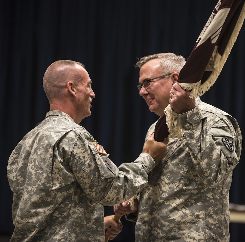 Command Sgt. Maj. Mark Allen, 3297th United States Army Hospital Battalion command sergeant major, passes the battalion colors to Col. James H. Murphy, 297th United States Army Hospital Battalion commander, so they may be properly rolled and cased during the battalion's Color Casing Ceremony in Charlotte, N.C., Aug. 20. The unit will be officially deactivated Sept. 15 and will transition to become the 7409th U.S. Army Troop Medical Clinic. (U.S. Army Reserve photo by Sgt. 1st Class Brian Hamilton/ released)