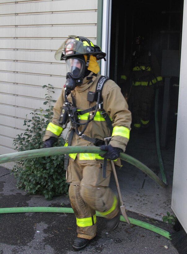 FORT MCCOY, Wis. – U.S. Army Reserve firefighters, from the 237th Firefighter Detachment, Sturtevant, Wis., exit the burn house after putting out a fire during an exercise at Fort McCoy, Aug. 21, 2016. Firefighter teams took turns entering the house and extinguishing fires to learn ever changing firefighting techniques. Firefighters can put out a 300-square foot fire in under a minute using either a water or foam-based method. (U.S. Army Reserve Photo by Sgt. Quentin Johnson, 211th Mobile Public Affairs Detachment/Released)
