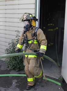 FORT MCCOY, Wis. – U.S. Army Reserve firefighters, from the 237th Firefighter Detachment, Sturtevant, Wis., exit the burn house after putting out a fire during an exercise at Fort McCoy, Aug. 21, 2016. Firefighter teams took turns entering the house and extinguishing fires to learn ever changing firefighting techniques. Firefighters can put out a 300-square foot fire in under a minute using either a water or foam-based method. (U.S. Army Reserve Photo by Sgt. Quentin Johnson, 211th Mobile Public Affairs Detachment/Released)