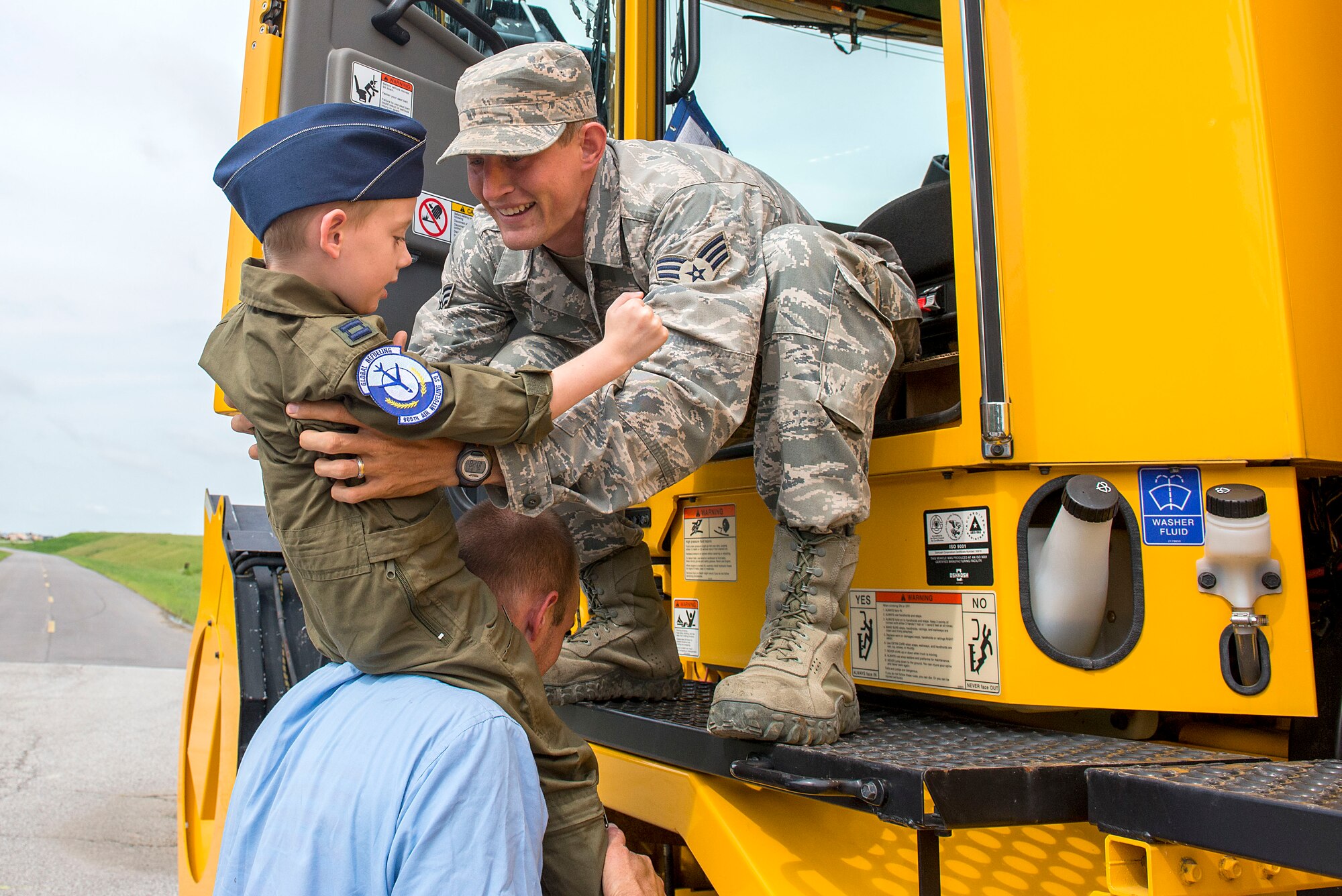 Senior Airman Ian Clark, 375th Civil Engineer Squadron, lifts Hayden Brown, 6, off the shoulders of his father Jonathan for a ride in a snow plow, Aug. 17, 2016, Scott Air Force Base, Ill. Scott Airmen teamed up with Alton VFW Post 1308 to present Hayden with a badge of courage for his determination in dealing with his rare, and terminal illness, known as MLD.  (U.S. Air Force photo by Senior Airman Megan Friedl)