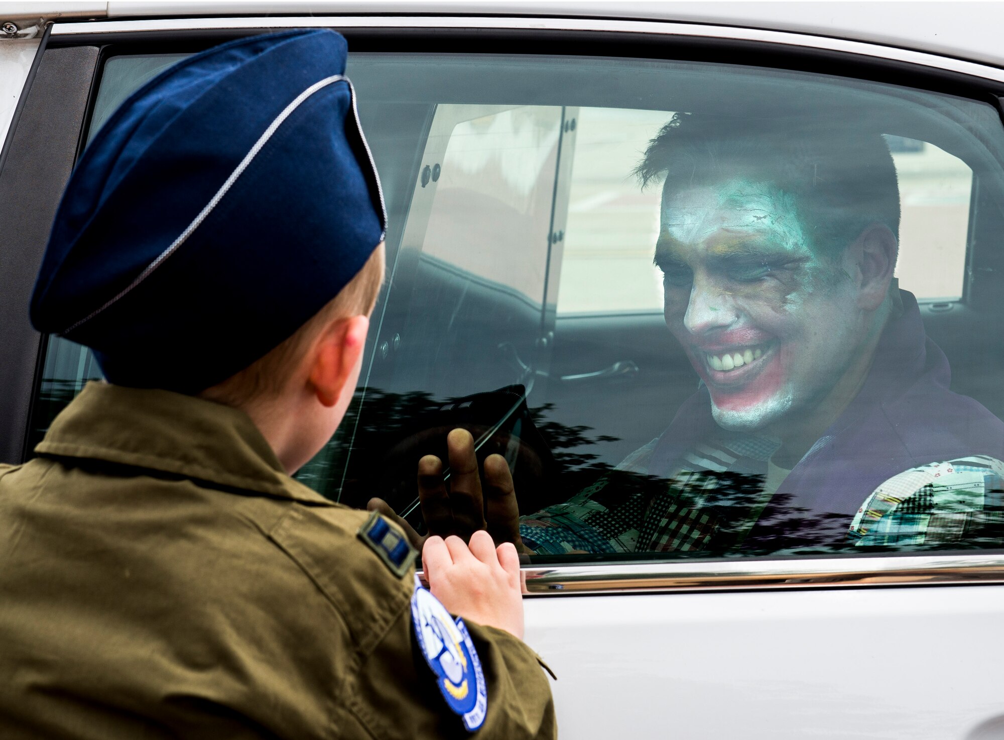 Hayden look into the cop car that holds the Joker (volunteer Staff Sgt. Brett Baxter, 375th SFS) as he's carted off to Jail.  Throughout the day, Hayden assisted in tracking down the Joker with the help of Batman. (U.S. Air Force photo by Senior Airman Megan Friedl.)