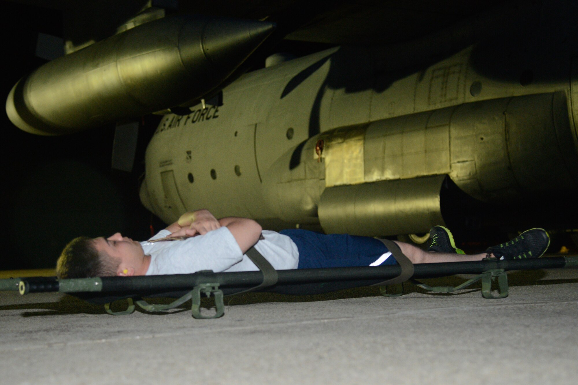 U.S. Airman 1st Class Tristan Smith, 51st Munitions Squadron crew member, simulates a patient awaiting transport during a medical evacuation scenario for Exercise Beverly Herd 16-2 at Osan Air Base, Republic of Korea, Aug. 25, 2016.  Beverly Herd is a wing-level exercise designed to maintain the readiness posture of the members of Osan, and the 51st AMDS continually train during the exercise to ensure “Fight Tonight” readiness. (U.S. Air Force photo by Senior Airman Dillian Bamman)