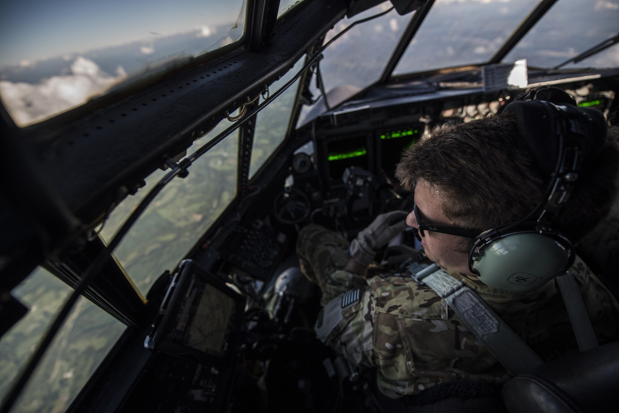 A pilot  with the 15th Special Operations Squadron scans the ground during routine low-level flying training during Task Force Exercise Olympus Archer at Wright Patterson Air Force Base, Ohio, Aug. 21, 2016. Olympus Archers' focus is to maximize training opportunities for more than 230 Air Commandos with the 1st Special Operations Wing with an emphasis on medical operations in conjunction with flying operations. (U.S. Air Force photo by Staff Sgt. Christopher Callaway)