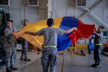 Airmen from the United States and Colombian Air Forces prepare a flag for display during Exercise Green Flag East at Barksdale Air Force Base, La., Aug. 15, 2016. Green Flag East provides pilots with simulated scenarios to train in a high-threat environment, and affords maintenance and support personnel an increased tempo in generating fully mission-capable combat aircraft. (U.S. Air Force photo/Senior Airman Mozer O. Da Cunha)