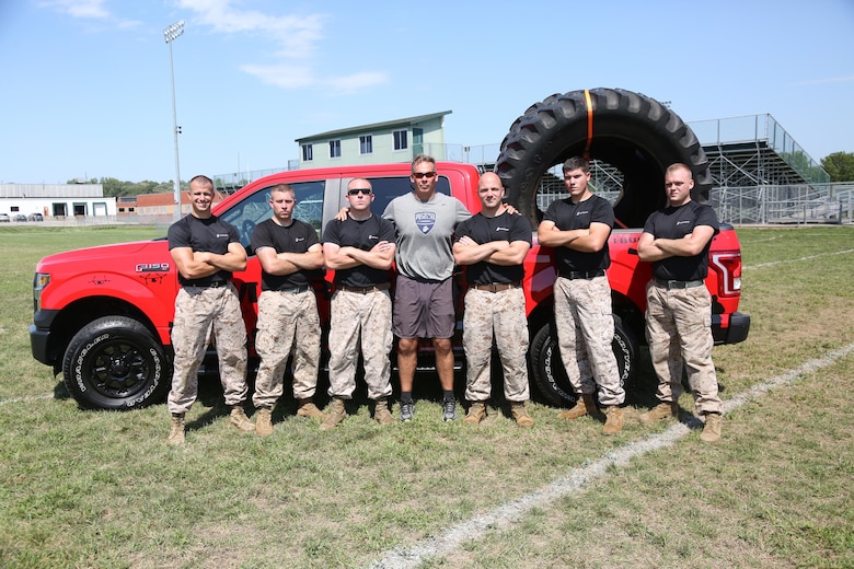 Marines from Recruiting Station Des Moines pose at the Football Leadership Camp at North High School Grubb Stadium, Aug. 18. Listed from left to right: Staff Sgt. Kaleb V. Wagy, Staff Sgt. Michael T. Huck, Sgt. Joseph E. Fralix, retired Maj. Sean Quinlan, Cpl. Brock T. Gaul and Cpl. Buray T. Kiser. (U.S. Marine Corps photo by Cpl. Jennifer Webster/Released)