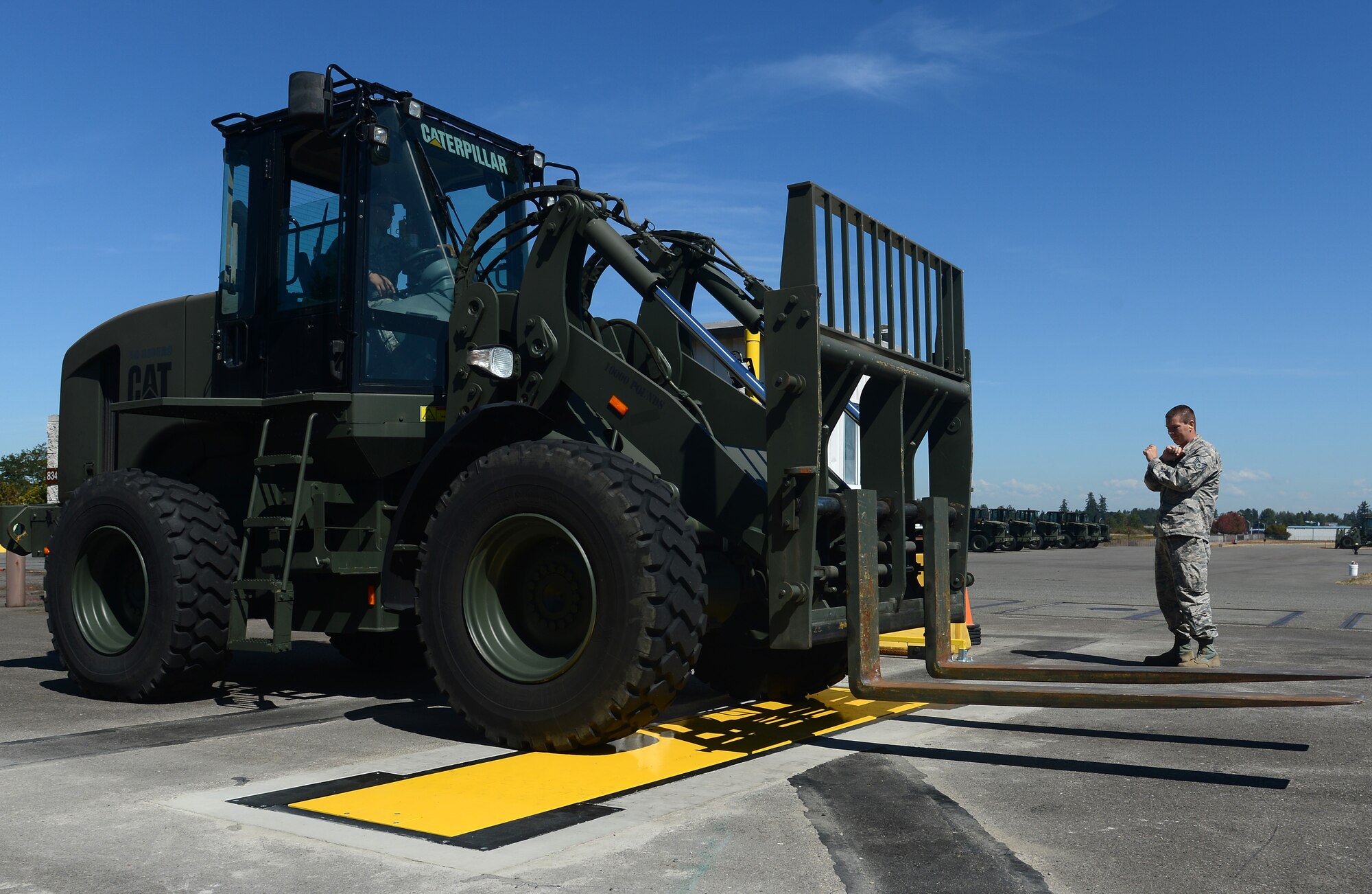 A forklift drives across a weigh-in-motion system Aug. 23, 2016 at Joint Base Lewis-McChord, Wash. The system, which consists of two laser-enabled reading posts and a digital floor-pad sensor, takes real-time and accurate measurements required for unit's automated load-planning systems. (U.S. Air Force photo/Senior Airman Divine Cox)