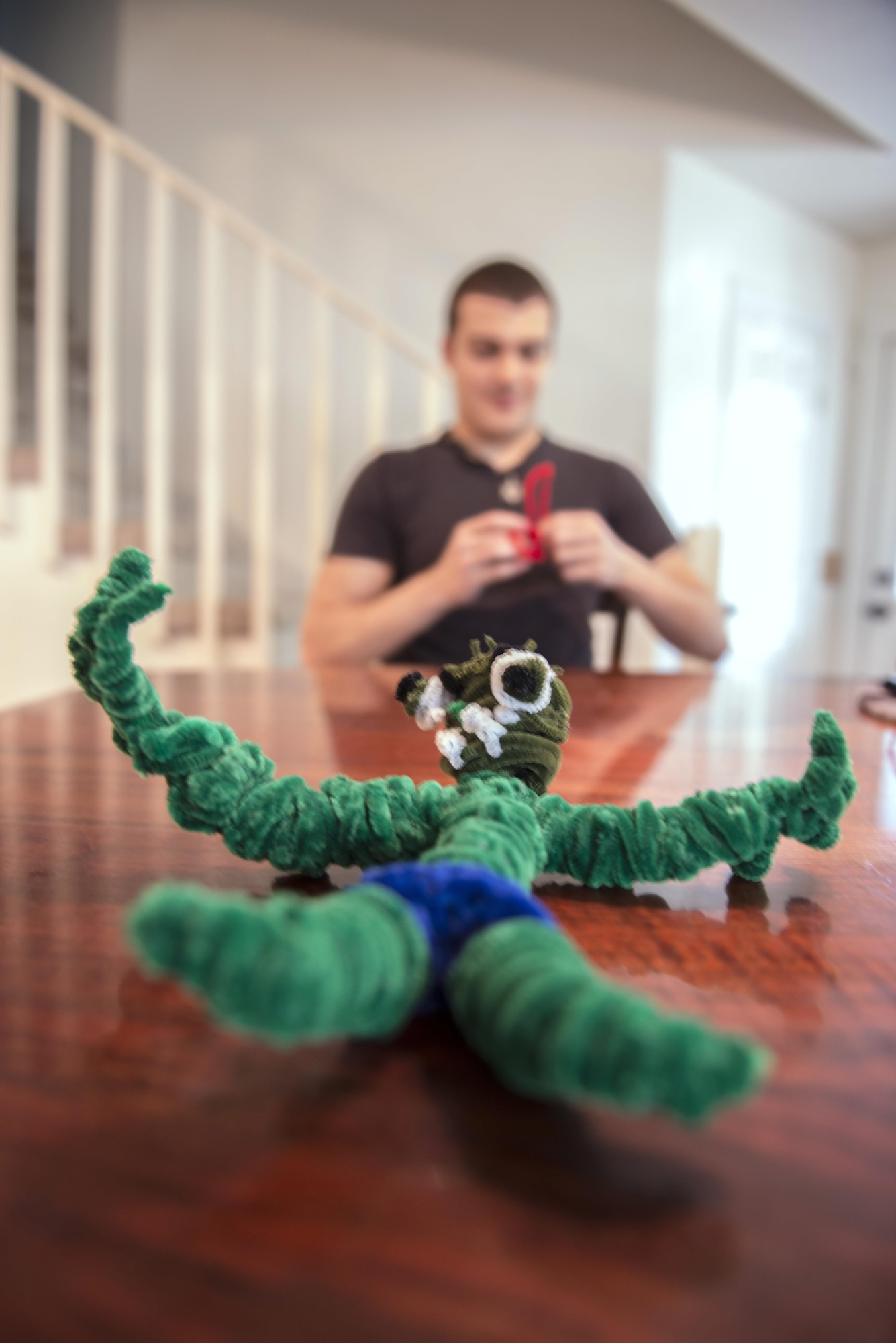 Robert Waid displays ‘The Incredible Hulk,’ which was his first piece of artwork created out of pipe cleaners eight years ago, as he works on a different project, July 25, 2016, at his home in North Pole, Alaska. Waid said he keeps this piece as a reminder of how far he came in creating art. (U.S. Air Force photo by Staff Sgt. Ashley Nicole Taylor)